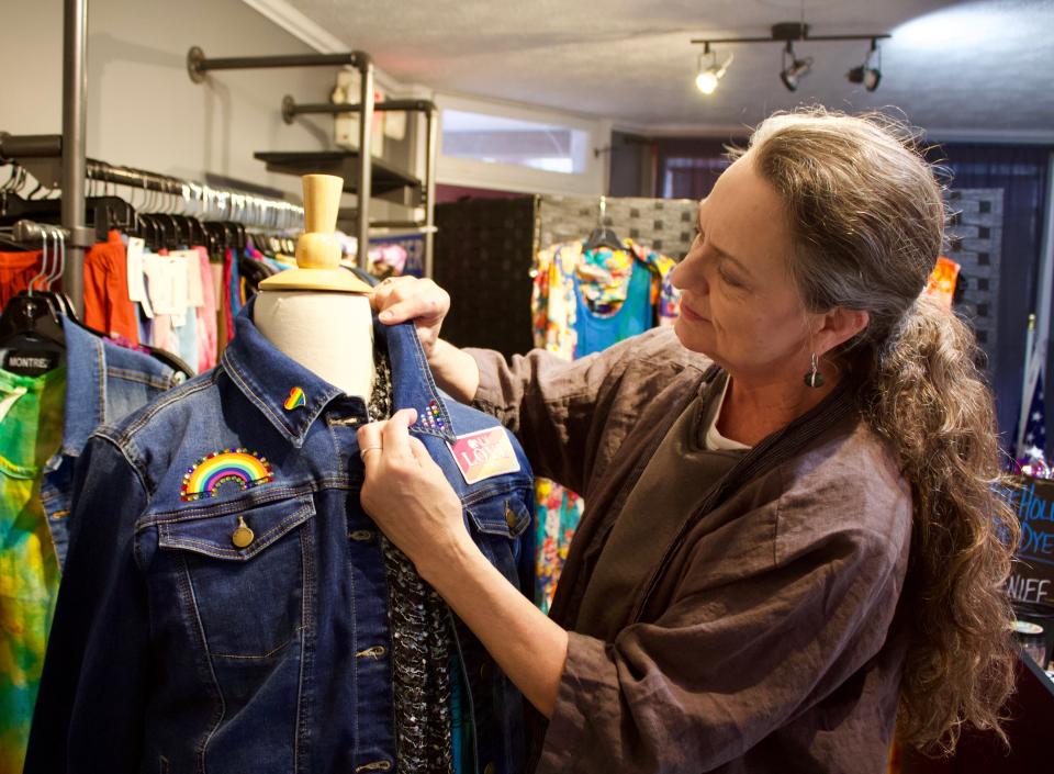 Lisa Smith adjusts a mannequin at Compass Tea Room, which also sells boutique clothing from designers around Luray, Virginia. Smith said the denim jackets with Pride-themed patches and pins sell very quickly.