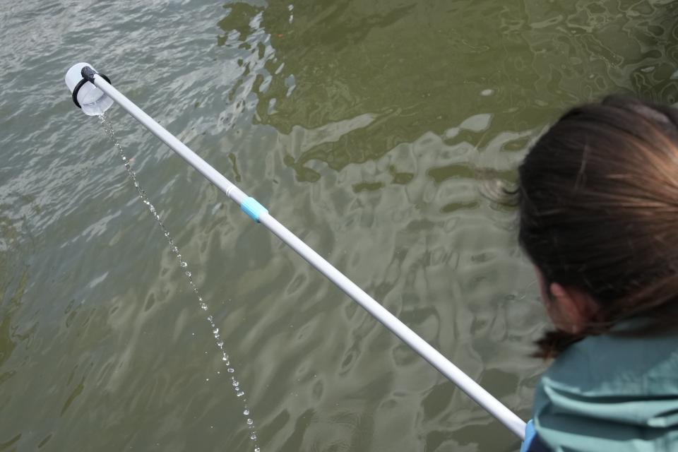 Maelys Hemon takes samples of water of the Seine river before a quality test Friday, Aug. 4, 2023, in Paris. Heavy rains have set back plans to test Paris’ readiness for swimmers to race in the River Seine at next year’s Summer Olympics. A planned training session Friday for swimmers aiming to compete this weekend in the river that cuts through Paris was canceled because the water quality dropped below acceptable standards, the international governing body of swimming announced. | Christophe Ena, Associated Press