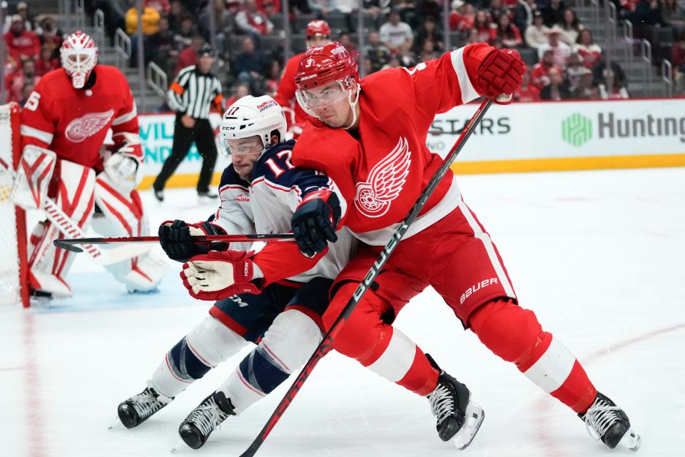 Columbus Blue Jackets right wing Justin Danforth (17) and Detroit Red Wings defenseman Justin Holl (3) battle for position in the first period of an NHL hockey game Saturday, Nov. 11, 2023, in Detroit. (AP Photo/Paul Sancya)