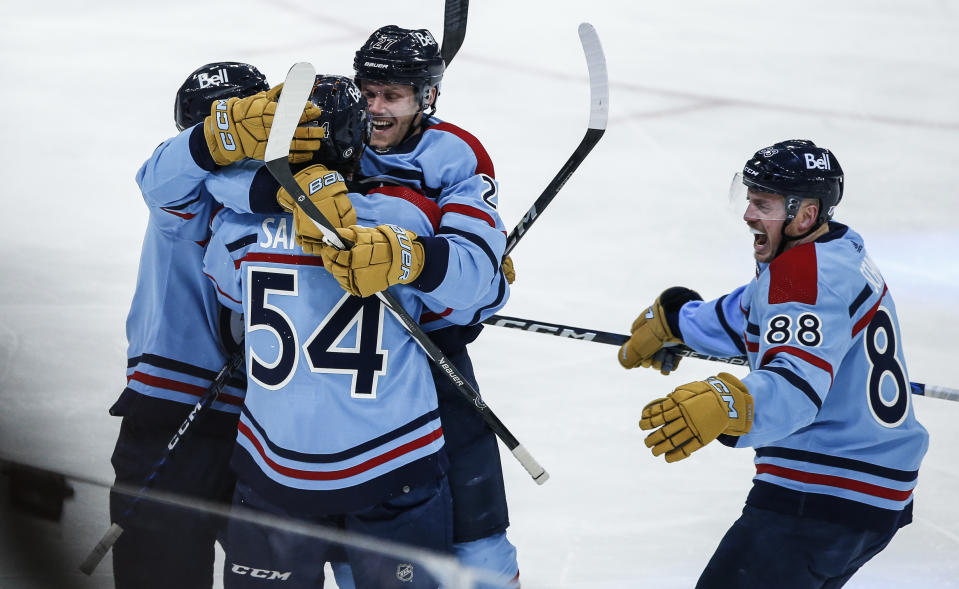 Winnipeg Jets' Kyle Connor (81), Dylan Samberg (54), Nikolaj Ehlers (27) and Nate Schmidt (88) celebrate Samberg's goal against the Toronto Maple Leafs during the first period of an NHL hockey game, Saturday, Jan. 27, 2024, in Winnipeg, Manitoba. (John Woods/The Canadian Press via AP)