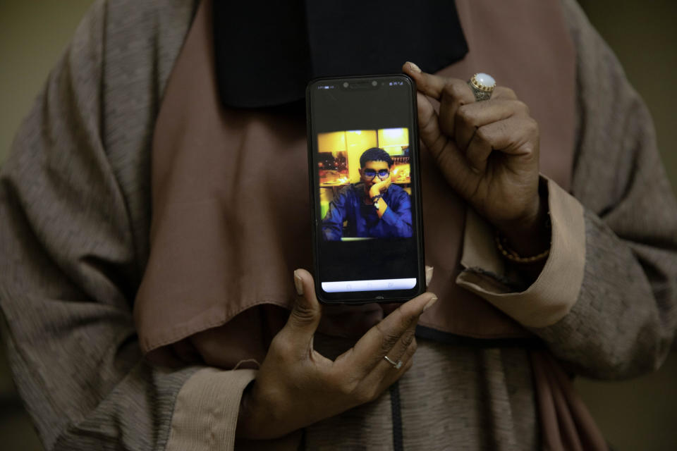 In this Jan. 11, 2020 photo, Sudanese Dr. Saadeya Seif, who lost her brother Awad Seif el-Din during last years' revolution shows a photograph of him on her phone, after a meeting with families who lost loved ones, at the Revolutionary Martyrs Center, in Khartoum, Sudan. The young protesters who led the uprising against former President Omar al-Bashir, are now caught in the limbo of the country's fragile interim period. Generals remain the de-facto rulers of the country and have shown little willingness to hand over power to a civilian-led administration, one the demonstrators' key demands. (AP Photo/Nariman El-Mofty)