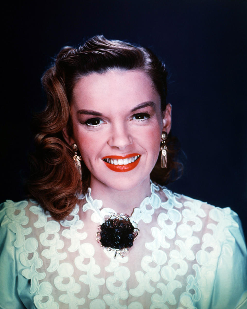 Garland wears a white lace blouse with and gold drop earrings in a studio portrait, circa 1950.&nbsp;