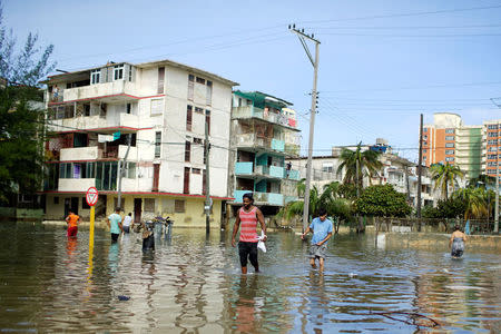 People walk in a flooded area after Hurricane Irma caused flooding and a blackout, in Havana, Cuba September 11, 2017. REUTERS/Alexandre Meneghini