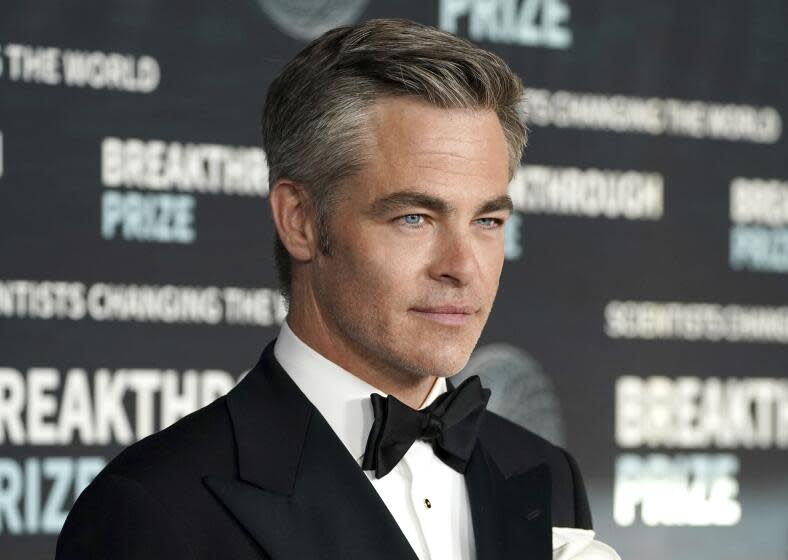 A closeup of Chris Pine's face showing the top of his tuxedo and black tie