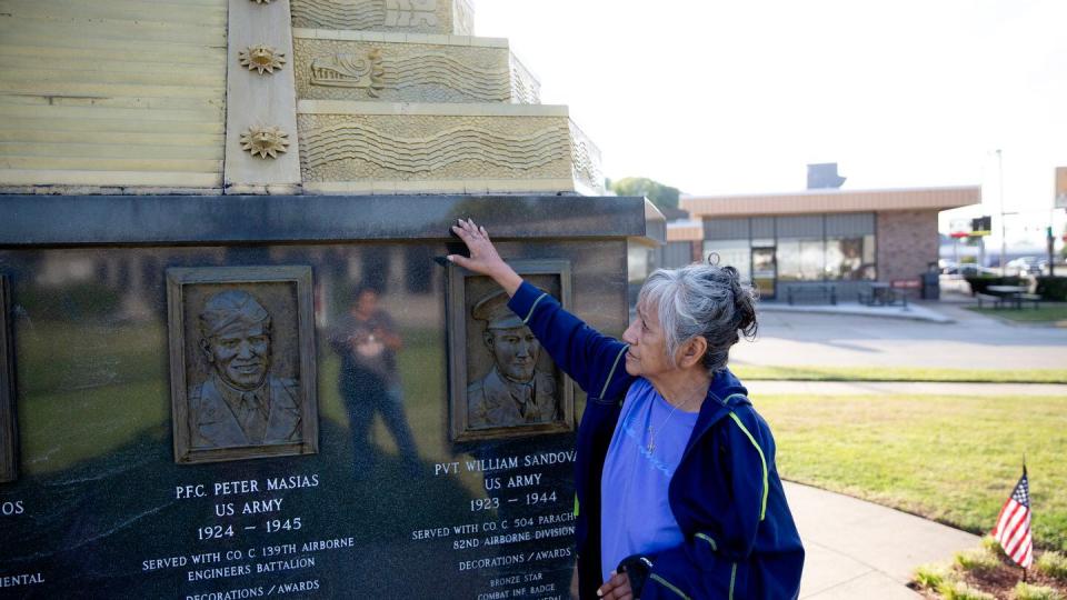 Maria Soliz remembers her uncle while at the monument on Hero Street. Soliz served on the committee advocating for a monument on the street. (Zamone Perez/Staff)