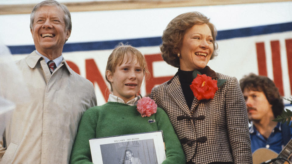 Former President Jimmy Carter acknowledges the crowd while standing on stage with his daughter Amy and wife Rosalynn upon the family's return to his hometown of Plains, Georgia, January 1981