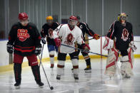 Members of the "1979" hockey club warm up on the ice before a hockey match at a rink in Beijing, Wednesday, Jan. 12, 2022. Spurred by enthusiasm after China was awarded the 2022 Winter Olympics, the members of a 1970s-era youth hockey team, now around 60 years old, have reunited decades later to once again take to the ice. (AP Photo/Mark Schiefelbein)