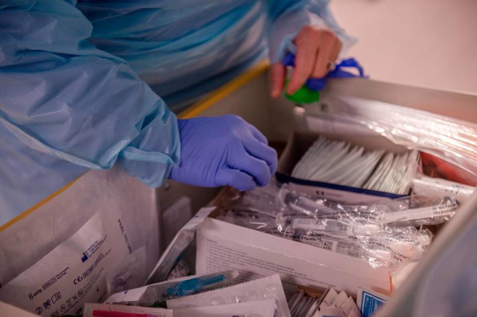 A nurse selects tools before entering a COVID-19 patient’s room in the ICU at Memorial Hospital in Gulfport on Wednesday, Aug. 11, 2021.