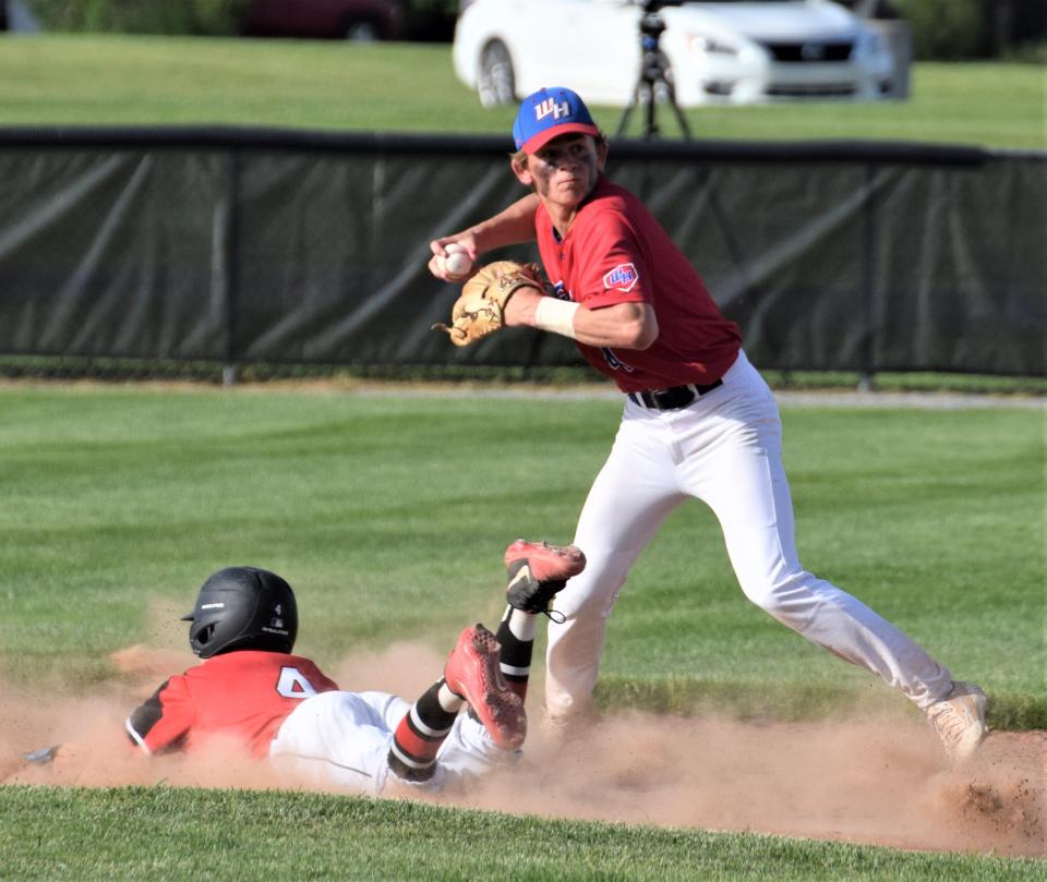 West Holmes shortstop Hunter Aurand avoids a sliding Quaker and fires to first to complete a 4-6-3 double play.