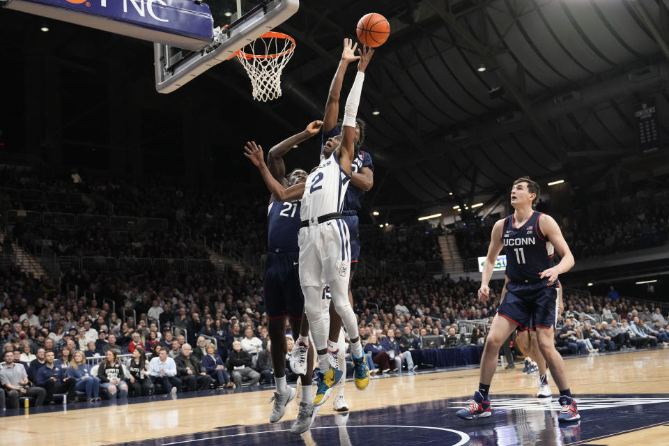 Butler guard Eric Hunter Jr., front center, shoots in front of Connecticut defenders Adama Sanogo, left, Tristen Newton, behind, and Alex Karaban (11) in the first half of an NCAA college basketball game in Indianapolis, Saturday, Dec. 17, 2022. (AP Photo/AJ Mast)