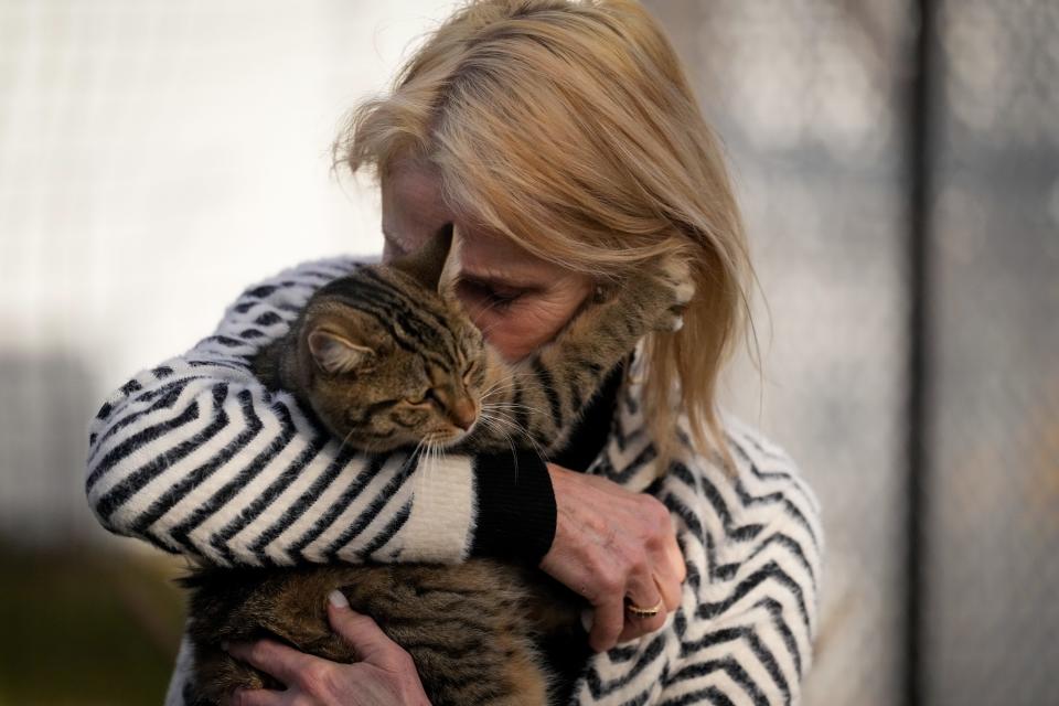 Jan Malley, co-founder of Shane's Sanctuary and Kitty Adoption Center, hugs one of her residents on the “catio."