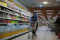 A worker removes French products from a supermarket, in Sanaa, Yemen, Monday, Oct. 26, 2020. Muslims in the Middle East and beyond on Monday called for boycotts of French products and for protests over caricatures of the Prophet Muhammad they deem insulting and blasphemous, but France's president has vowed his country will not back down from its secular ideals and defense of free speech. (AP Photo/Hani Mohammed)