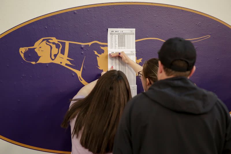 Participants check a lineup list during the Masters Agility Championship during the Westminster Kennel Club Dog Show in New York