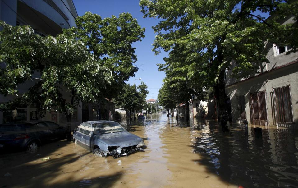 A damaged car is seen stranded in flood waters in the town of Obrenovac