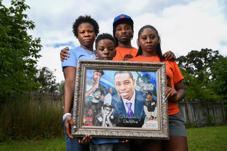 Akilah DaSilva's family holds a portrait of him.