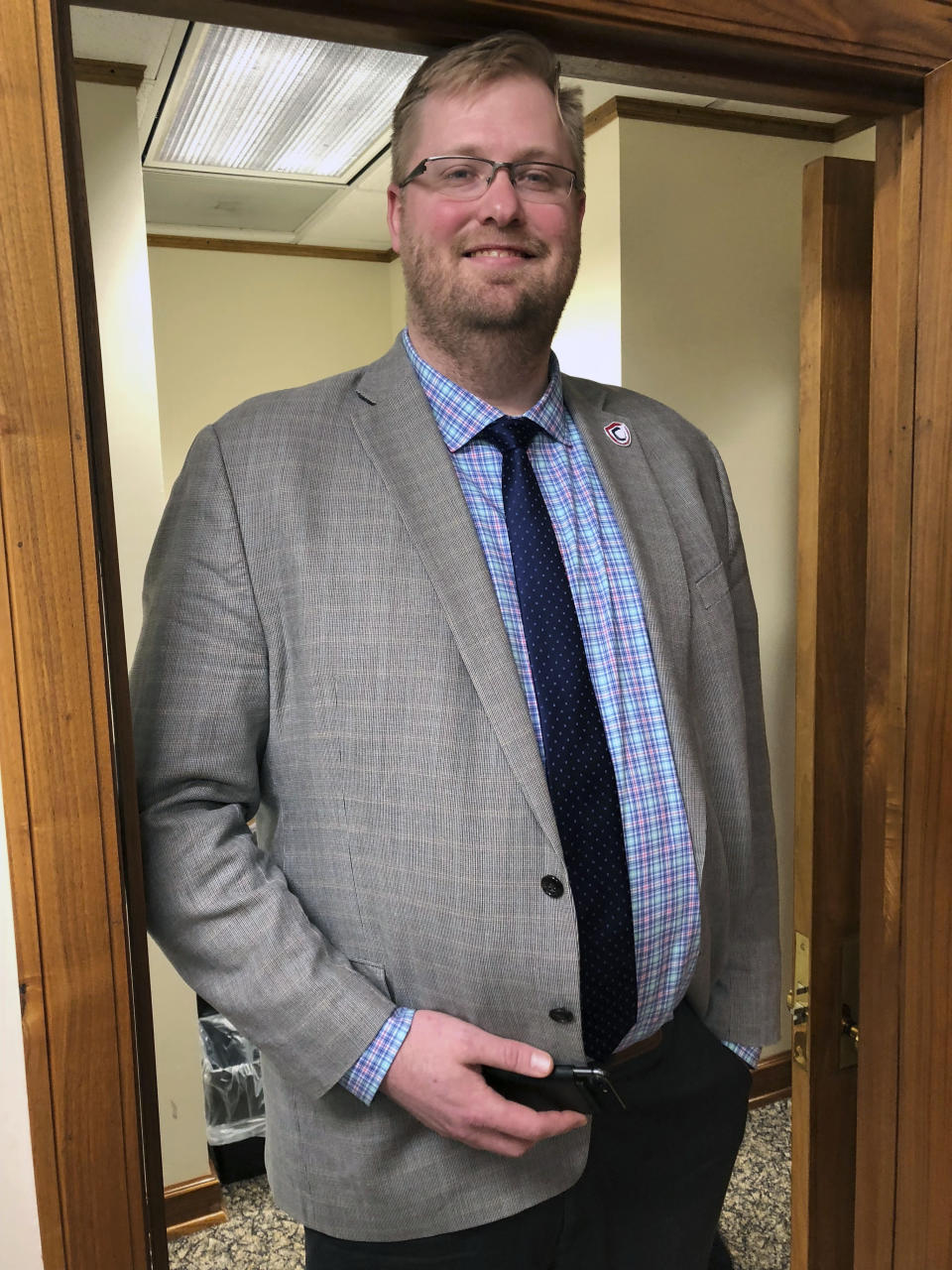 North Dakota Insurance Commissioner Jon Godfread poses for a portrait at the state Capitol in Bismarck, N.D., Thursday, March 28, 2019. Godfread, who claims he is 6-foot-11 3/4 inches, is challenging New York City councilman Robert Cornegy Jr., a 6-foot-10 councilman from Brooklyn's claim of being the tallest male politician in the world. Comegy was certified by Guinness World Records in January. But wait, Brad Sellers, a former Ohio State and Chicago Bulls star listed at 7 feet, also says he has a claim. Sellers is now the mayor of Warrensville Heights, Ohio. (AP Photo/James MacPherson).