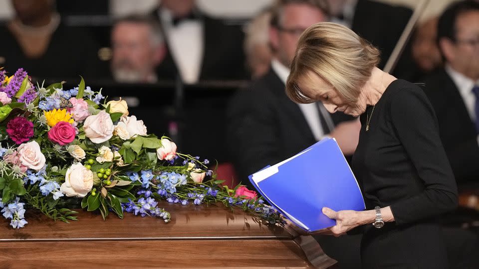 Journalist Judy Woodruff pauses at the casket of first lady Rosalynn Carter, after speaking at Wednesday's tribute service. - Brynn Anderson/AP