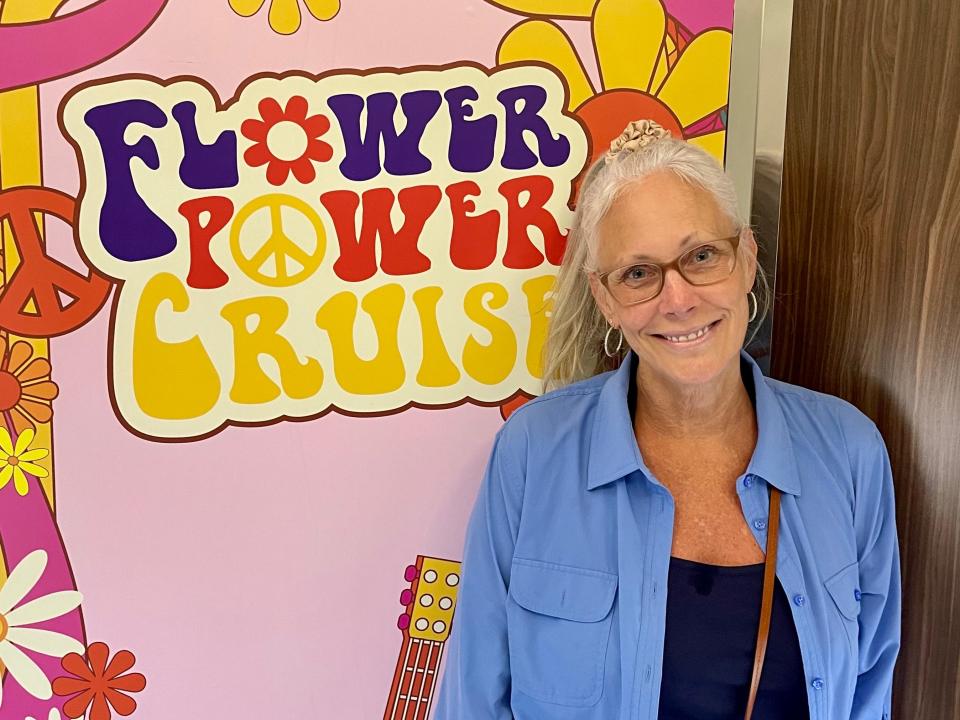 The writer in front of a small Flower Power Cruise sign