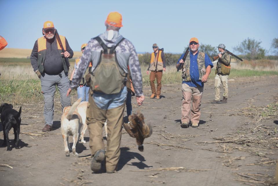 Out-of-state hunters Tom Jackson, Logan Fendley, Ronnie Cox and Cameron Fendley approach guide Q McEntee during pheasant hunting opening day, October 16, 2021 in Iona, South Dakota.