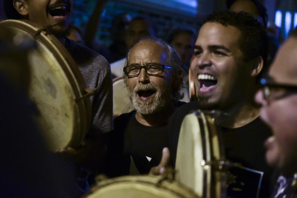 People celebrate after learning that President Barack Obama commuted the sentence for Puerto Rican nationalist Oscar Lopez Rivera, in San Juan, Puerto Rico, Tuesday, Jan. 17, 2017. Many Puerto Ricans have long demanded the release of Lopez, who was sentenced to 55 years in prison for his role in a violent struggle for independence for the U.S. island territory. (AP Photo/Carlos Giusti)