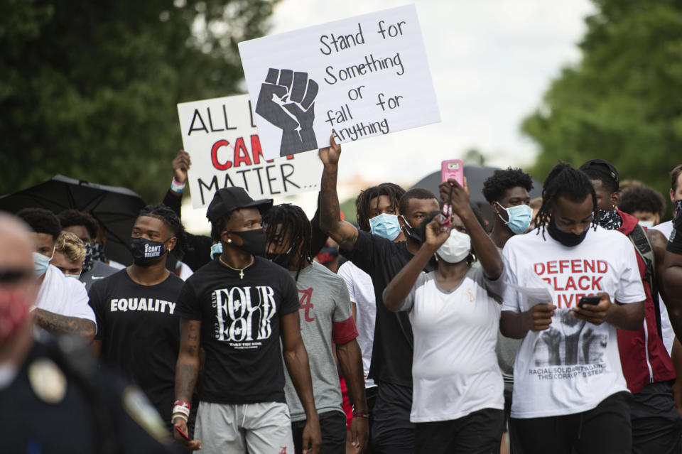 FILE - The University of Alabama football team displays signs as they and fellow athletes from other sports march on campus, supporting the Black Lives Matter movement, Monday, Aug. 31, 2020, in Tuscaloosa, Ala. (AP Photo/Vasha Hunt, File)