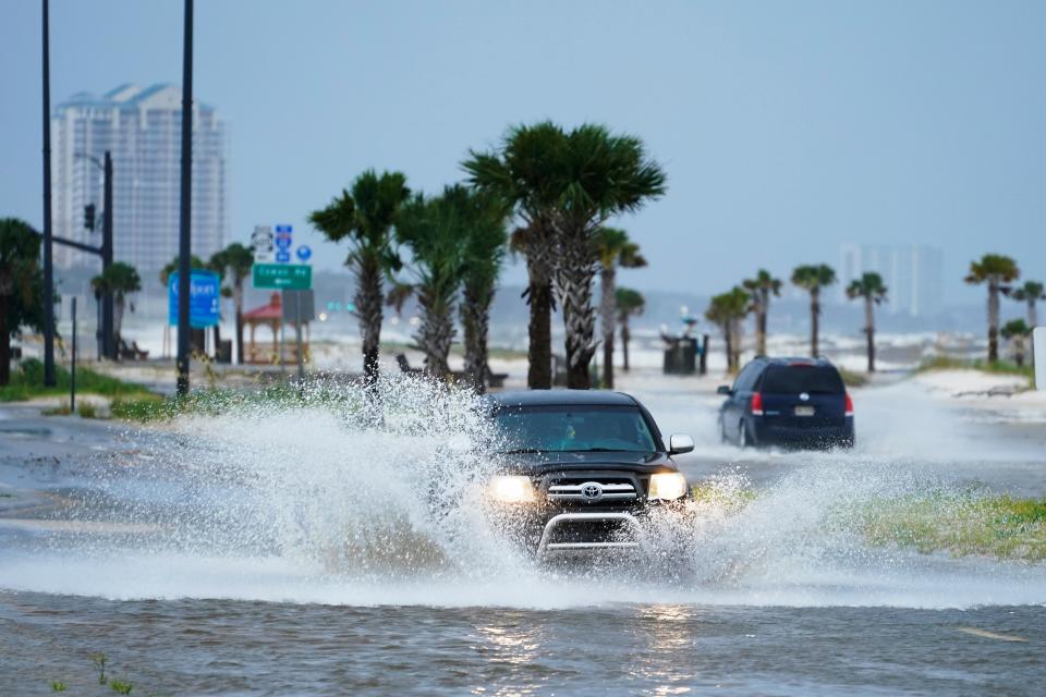 Cars drive through flood waters along route 90 as outer bands of Hurricane Ida arrive Sunday, Aug. 29, 2021, in Gulfport, Miss. (AP Photo/Steve Helber) (AP)