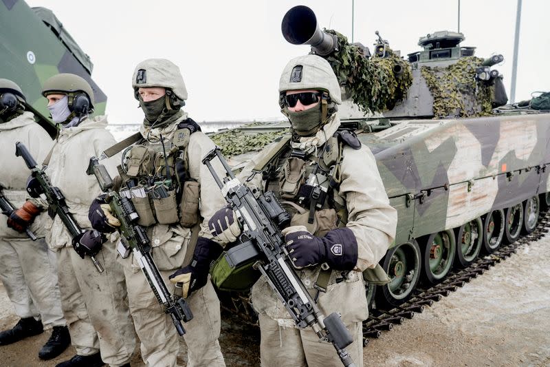 FILE PHOTO: Soldiers stand next to a military vehicle as Norwegian, Swedish and Finnish forces participate in a military exercise, in Kautokeino