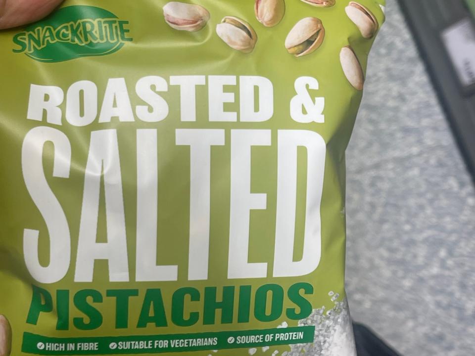 hand holding a bag of pistachios at aldi