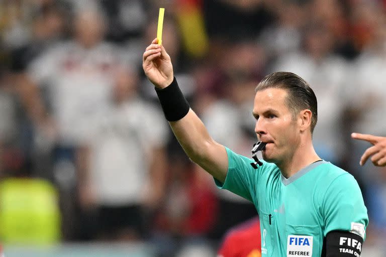 Dutch referee Danny Makkelie presents a yellow card to Germany's midfielder #08 Leon Goretzka during the Qatar 2022 World Cup Group E football match between Spain and Germany at the Al-Bayt Stadium in Al Khor, north of Doha on November 27, 2022. (Photo by Glyn KIRK / AFP)