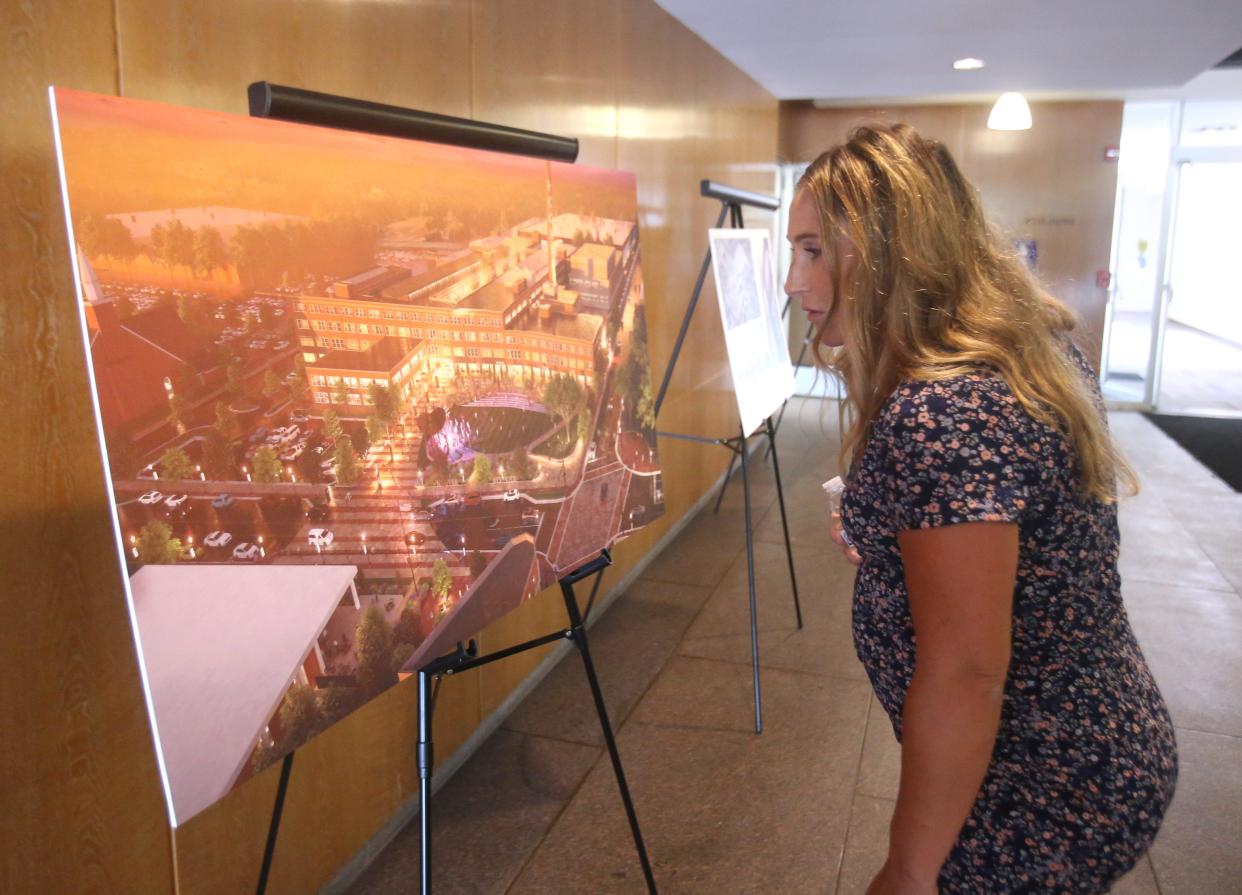 Michelle Nicholson studies a rendering for planned changes for the Hoover District  in North Canton during a tour on Wednesday. State officials visited the site after announcing a $5 million Ohio Historic Preservation Tax Credit for the project.