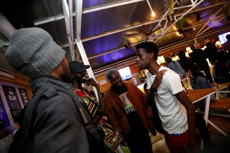 Kenyan standup comedian Brian Onjoro speaks to his colleagues after his performance at the Kez's Kitchen restaurant in Nairobi