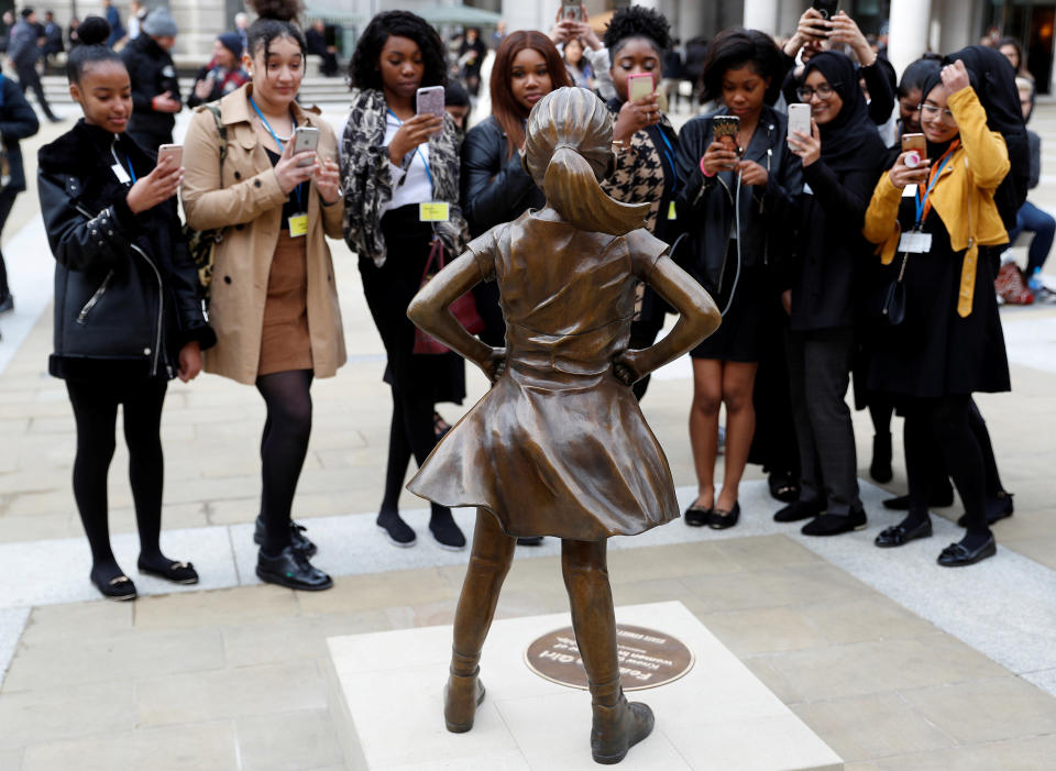 Students from some of London's all girls' schools, take pictures of the 'Fearless Girl' statue unveiled by State Street in the financial district of London, Britain, March 5, 2019. (Photo: Peter Nicholls/Reuters)