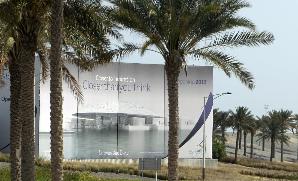 A giant billboard announces the 2015 opening of the Abu Dhabi branch of the Louvre construction site in Abu Dhabi, United Arab Emirates, Tuesday, April 16, 2013. The curator of the Abu Dhabi branch of the Louvre says no artistic subjects are off limits as the museum builds its collection. The Louvre is part of wider plans by Abu Dhabi for a cultural district that will also include a Guggenheim branch and a national museum. The sites have faced repeated construction delays. (AP Photo/Kamran Jebreili)