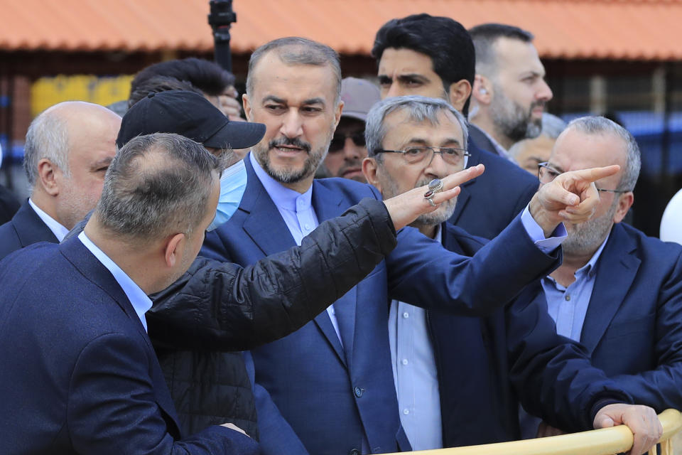 Iranian Foreign Minister Hossein Amirabdollahian, center, escorted by Hezbollah members and lawmakers points to the Israeli side during his visit to Iran park, in the village of Maroun el-Rass on the Lebanon-Israel border, south Lebanon, Friday, April 28, 2023. Amirabdollahian's first visit to Lebanon after Iran and Saudi Arabia reached an agreement in China last month to re-establish diplomatic relations and reopen embassies after seven years of tension that had major effects on Lebanon. (AP Photo/Mohammed Zaatari)