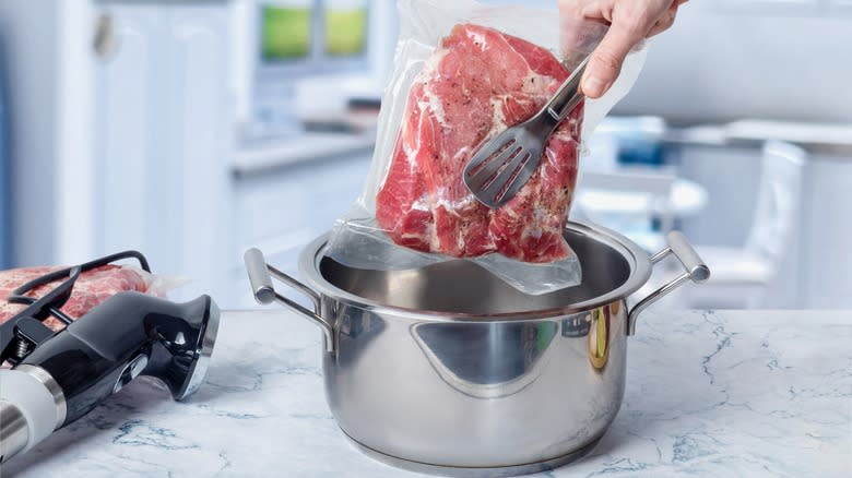 Placing vacuum sealed meat in pot