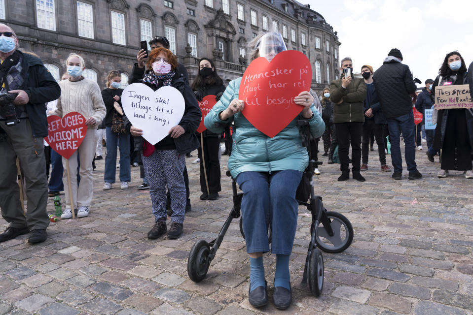 People attend a demonstration against the tightening of Denmark’s migration policy and the deportation orders in Copenhagen, Denmark, Wednesday, April 21, 2021. Poster in the center reads: “People on the run have the right to protection.” Ten years after the start of the Syrian civil war, Denmark has become the first European country to start revoking the residency permits of some refugees from the Damascus area. (AP Photo/David Keyton)