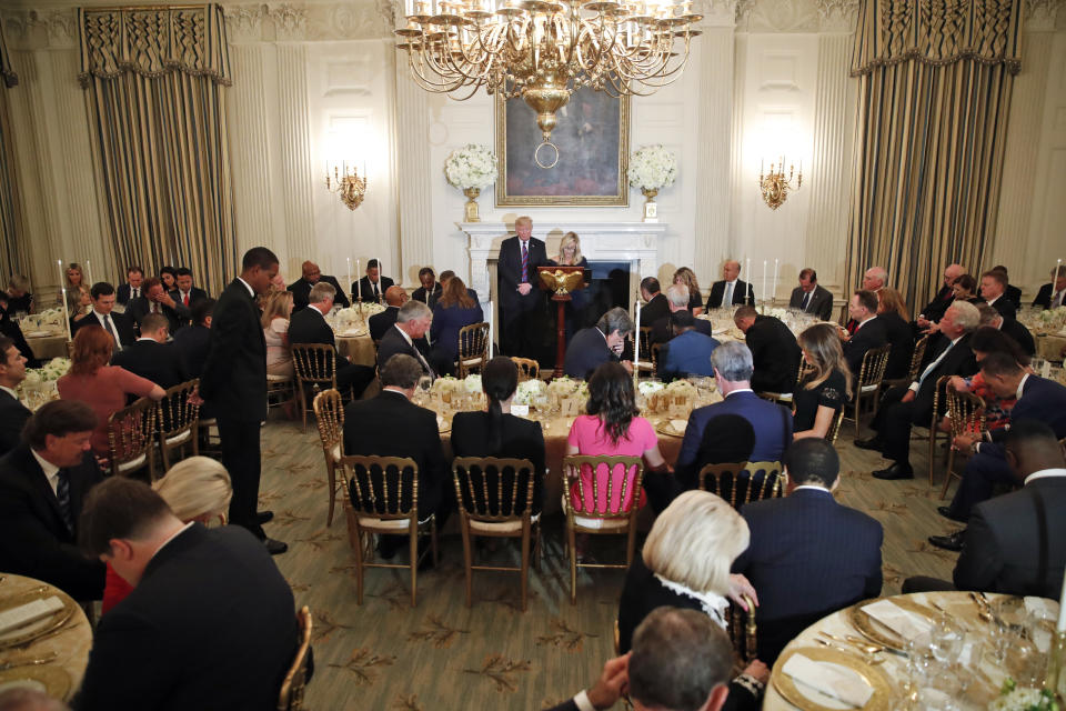 President Donald Trump bows his head in prayer as pastor Paula White leads the room in prayer during a dinner for evangelical leaders in the State Dining Room of the White House, Monday, Aug. 27, 2018, in Washington. (AP Photo/Alex Brandon)