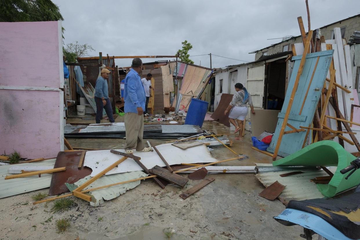 Residents stand amid their homes that were damaged by Hurricane Fiona in the low-income neighborhood of Kosovo in Veron de Punta Cana, Dominican Republic, Monday, Sept. 19, 2022.