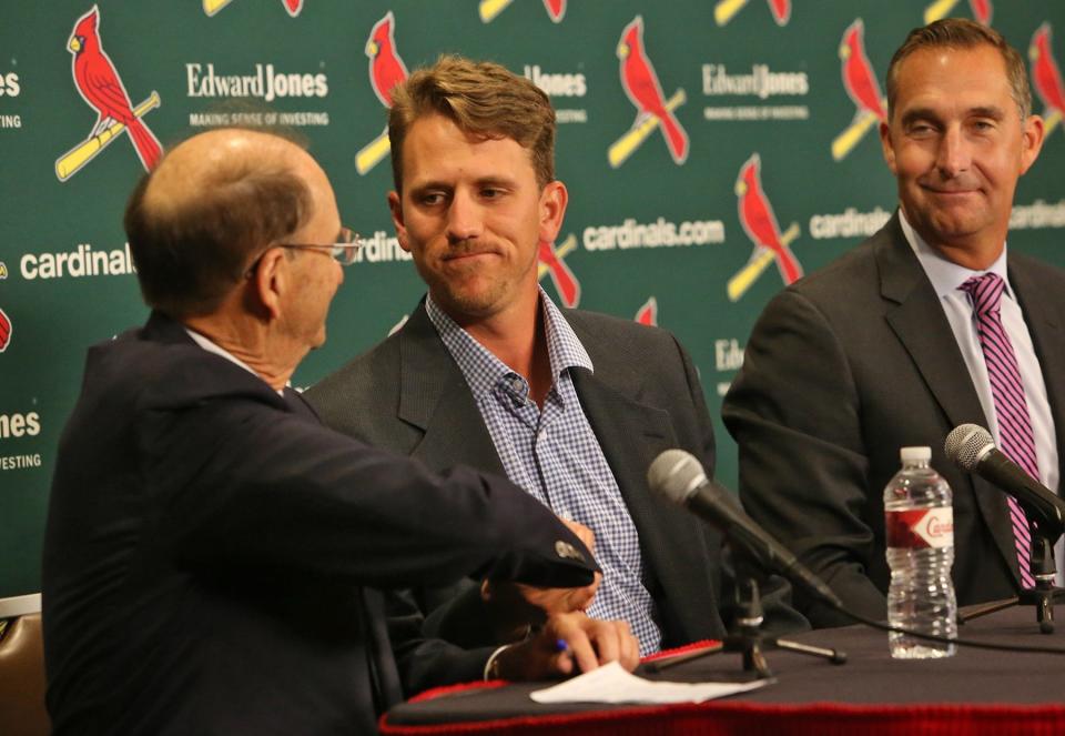 St. Louis Cardinals Chairman Bill DeWitt, left, congratulates Stephen Piscotty on signing a long-term contract with the Cardinals, during a press conference Monday, April 3, 2017, in St. Louis. At right is Cardinals General Manager John Mozeliak. (J.B. Forbes/St. Louis Post-Dispatch via AP)