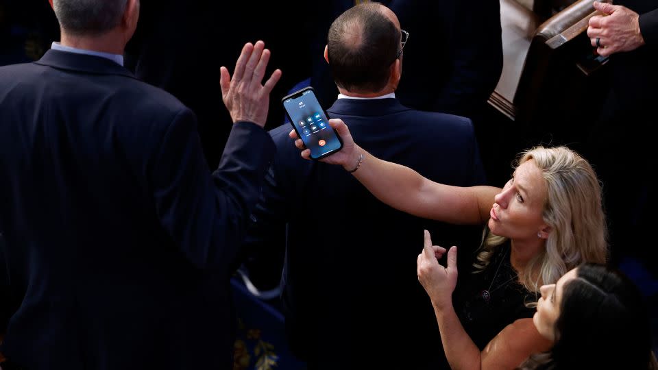 Matt Rosendale refuses to talk with former President Donald Trump on a phone being offered by Marjorie Taylor Greene during the last moments of a contentious debate on the fourth day of voting for a new speaker of the House on January 7, 2023, in Washington, DC. - Chip Somodevilla/Getty Images