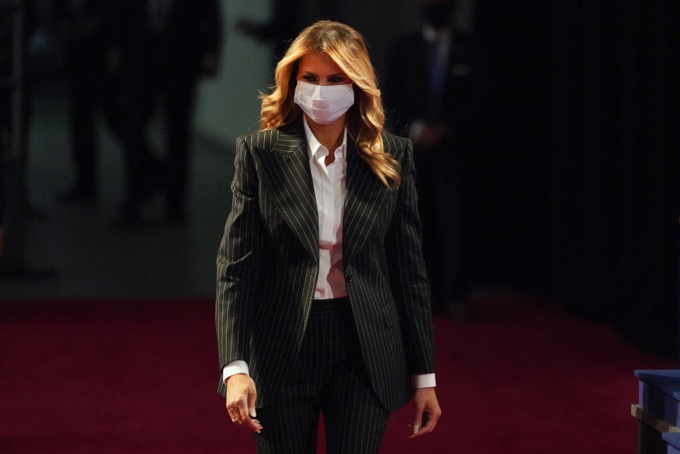 In this Sept. 29, 2020, file photo, first lady Melania Trump, wearing a facemask, walks towards her seat for the during the first presidential debate Tuesday, Sept. 29, 2020, at Case Western University and Cleveland Clinic, in Cleveland, Ohio. President Donald Trump and first lady Melania Trump have tested positive for the coronavirus, the president tweeted early Friday. (AP Photo/Julio Cortez)