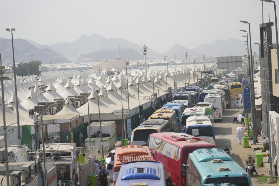 Muslim pilgrims arrive at the Mina tent camp during the annual Hajj pilgrimage, near the holy city of Mecca, Saudi Arabia, Friday, June 14, 2024. Hajj is the annual Islamic pilgrimage to Mecca in Saudi Arabia that is required once in a lifetime of every Muslim who can afford it and is physically able to make it. Some Muslims make the journey more than once. (AP Photo/Rafiq Maqbool)