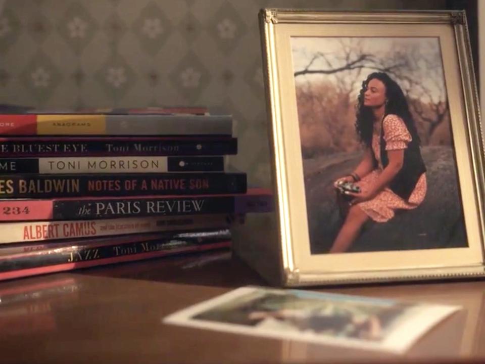 A stack of books and a framed photo of a woman on a table in "Gossip Girl."