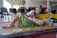 Physician Karen Calkins tends to Mona Guibord, 94, as she waits to be evacuated from Pine Island, Fla., in the aftermath of Hurricane Ian on Saturday, Oct. 1, 2022. The only bridge to the island is heavily damaged so it can only be reached by boat or air. (AP Photo/Gerald Herbert)