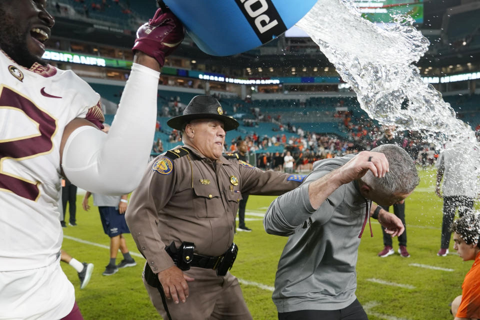 Florida State head coach Mike Norvell, right, is dunked with liquid after an NCAA college football game against Miami, Saturday, Nov. 5, 2022, in Miami Gardens, Fla. Florida State won 45-3. (AP Photo/Lynne Sladky)