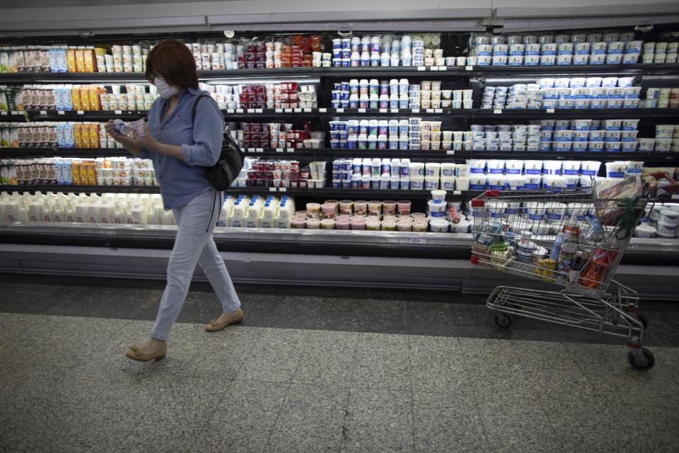 A woman shops at a supermarket in Caracas, Venezuela, Friday, June 4, 2021. Two years ago Venezuela stopped restricting transactions in dollars, which has largely ended shortages but has meant many Venezuelans, who are paid in bolivars, can't afford what's on those shelves. (AP Photo/Ariana Cubillos)