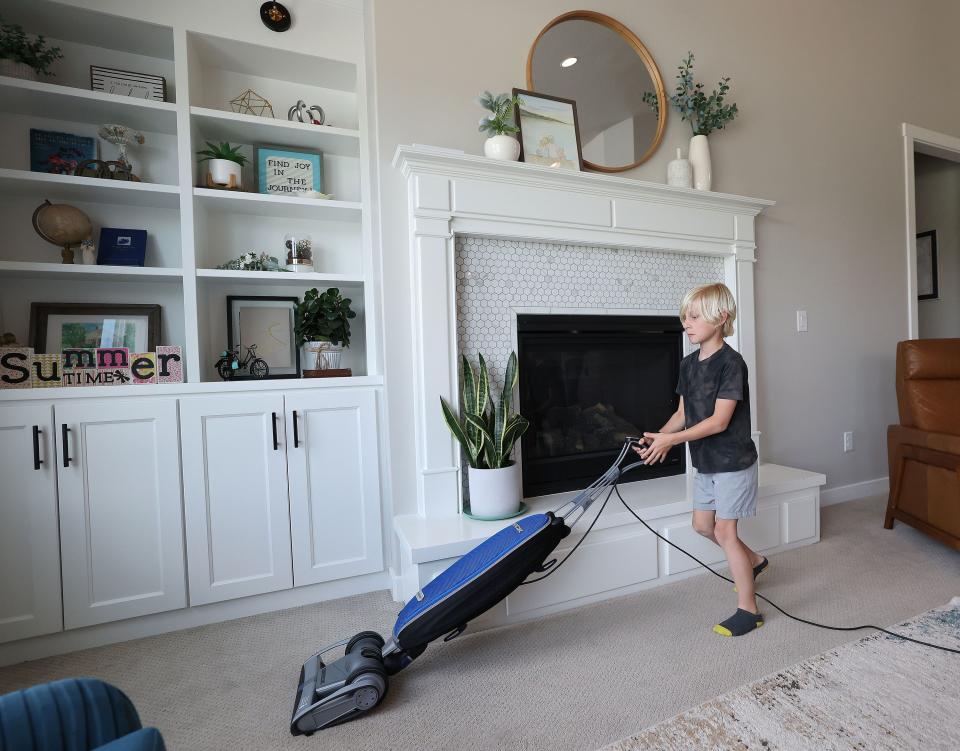 Porter Evanson vacuums at home in Lehi on Thursday, May 18, 2023. | Jeffrey D. Allred, Deseret News