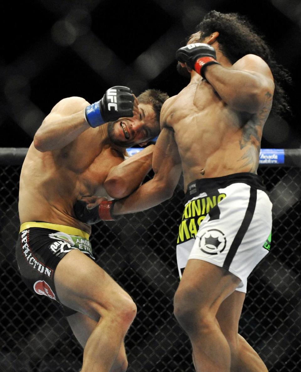 Benson Henderson, right, punches Josh Thomson, left, during the main event of a UFC mixed martial arts match in Chicago, Saturday, Jan. 25, 2014. (AP Photo/Paul Beaty)