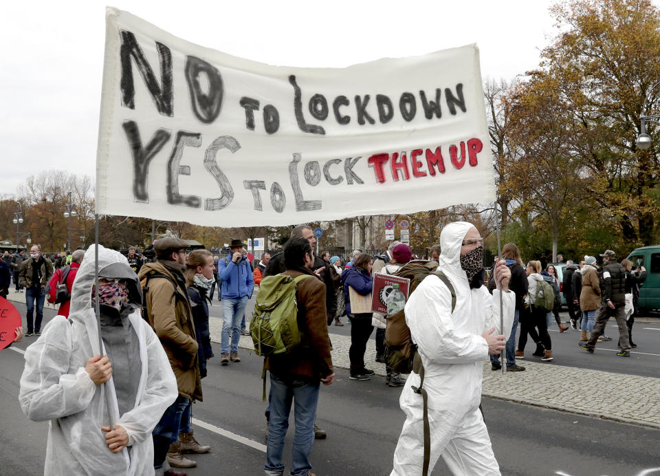 People attend a protest rally in front of the Brandenburg Gate in Berlin, Germany, Wednesday, Nov. 18, 2020 against the coronavirus restrictions in Germany. Police in Berlin have requested thousands of reinforcements from other parts of Germany to cope with planned protests by people opposed to coronavirus restrictions. (AP Photo/Michael Sohn)