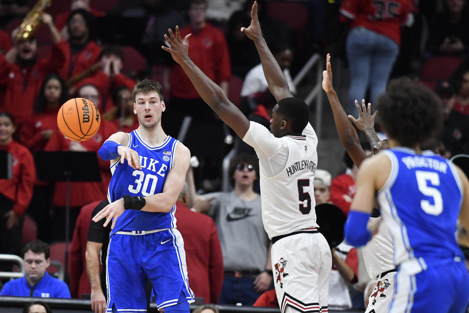 Duke center Kyle Filipowski (30) passes the ball away from the defense of Louisville forward Brandon Huntley-Hatfield (5) during the second half of an NCAA college basketball game in Louisville, Ky., Tuesday, Jan. 23, 2024. Duke won 83-69. (AP Photo/Timothy D. Easley)